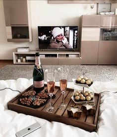 a tray that has some food and drinks on it with a tv in the background