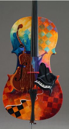 a colorful violin is on display in front of a gray background with an orange and black checkerboard design