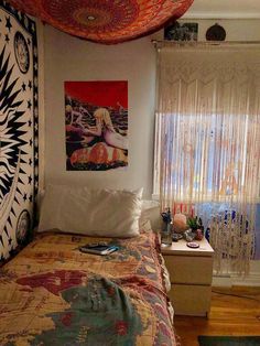 a bed room with a neatly made bed and a painting on the wall above it