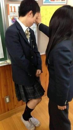 two people in school uniforms standing next to each other