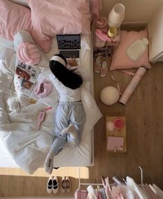 a woman laying on top of a bed next to a laptop computer and other items