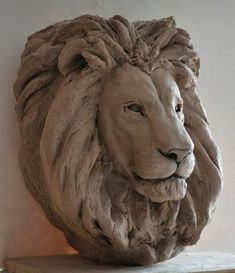 a statue of a lion head on top of a wooden shelf next to a wall