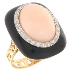 This exquisite ring embodies a luxurious fusion of exquisite design and craftsmanship, masterfully crafted in 18 karat white and yellow gold. It stands as a stunning example of how precious materials can be combined to create a piece of jewelry that instantly draws attention and celebrates the beauty of nature and artisan skill. At the heart of the ring sits a charming pink coral, known for its gentle and soothing shades, symbolizing protection and eternal love. This central gem is expertly set Elegant Evening Rings With Center Stone, Exquisite Evening Gemstone Rings, Formal Fine Jewelry Ring With Cabochon, Formal Fine Jewelry Cabochon Ring, Elegant Brilliant Cut Diamond Enamel Ring, Elegant Yellow Gold Enamel Ring With Polished Finish, Elegant Enamel Diamond Ring With Brilliant Cut, Elegant Gemstone Rings For Evening, Exquisite Yellow Gold Rings For Evening