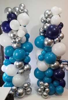 two tall blue and white balloons are next to each other