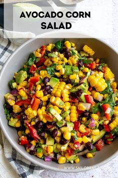 a white bowl filled with corn salad on top of a table