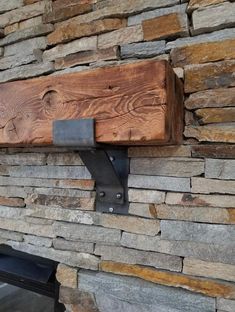 a wooden shelf mounted to the side of a stone wall