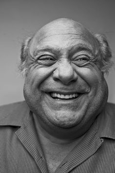 black and white photograph of an older man smiling at the camera with his eyes wide open