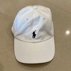 Polo Cap Brand: Polo Ralph Lauren Color: White Condition: Never Worn Size: 12-24 Months Casual White Dad Hat With Flat Bill, Basic White Cotton Baseball Cap, White Sporty Dad Hat With Flat Bill, White Adjustable Cotton Baseball Cap, White Cotton Flat Bill Hat, Casual White Baseball Cap With Embroidered Logo, Basic White Hat, One Size Fits Most, White Basic Hat One Size Fits Most, White Basic Hat