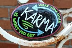 a close up of a metal object with graffiti on it's face and writing that says karna