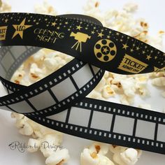 a film strip with popcorn on it and the words opening night next to it is surrounded by scattered popcorn