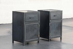 two black metal cabinets sitting on top of a cement floor