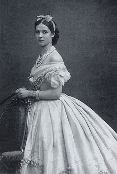 an old black and white photo of a woman in a dress