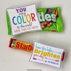 two candy bars with colorful labels on them sitting next to each other and one has a note that says you bring color to the world more than you know