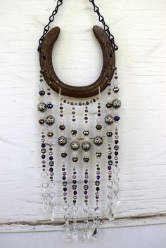 an old horseshoe hanging on a wall with beads