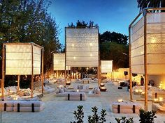 an outdoor seating area is lit up with candles