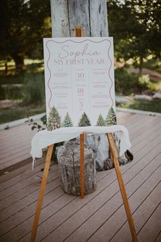 a sign that is on top of a wooden easel with a white table cloth draped over it