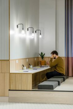 a man sitting on a bench in front of a desk