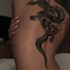 a woman with a dragon tattoo on her back