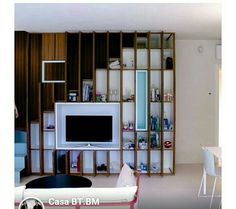 a living room filled with furniture and a flat screen tv sitting on top of a wooden shelf