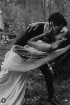 black and white photograph of a man kissing a woman on the cheek with her arm around him