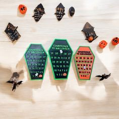 three halloween themed magnets sitting on top of a wooden table next to bats and pumpkins