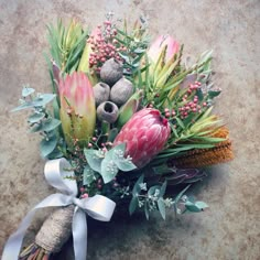 an arrangement of flowers and foliage on the ground