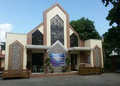 a church with two benches in front of it and a large window on the side