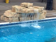 a small pool with water coming out of it and some rocks on the side of it