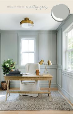 a desk with a chair, lamp and potted plant on it in front of a window