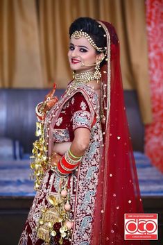 a woman in a red and gold bridal outfit