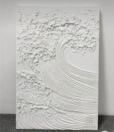 a large white sculpture sitting on top of a floor next to a black and white wall