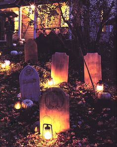 a house decorated for halloween with lighted pumpkins and tombstones