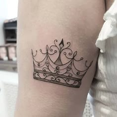 a black and white tattoo of a crown