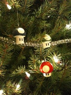 some ornaments are hanging from a christmas tree in the shape of houses on a wire