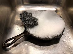 a spoon full of sugar sitting on top of a metal sink