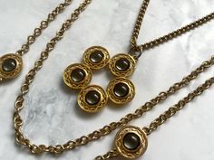 This is: An original vintage gold tone triple strand necklace from the 60s/70s by 'Celebrity' New York. Smooth rivoli glass crystal-decorated metalwork pendant and circular disc connectors with central rivoli glass crystal. Decorative hinged clip fastening. The 30" chain holding the pendant is connected by spring rings and can be removed and worn separately. Similarly the remaining chains can be worn without it as a double-strand necklace. Good quality and condition. Length of longest chain: 40" Antique Jewelry Necklace, Double Strand Necklace, Necklace Vintage, Glass Crystal, Antique Jewellery, Strand Necklace, Vintage 60s, Vintage Watches, Spring Rings