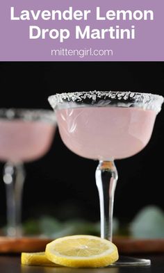 lavender lemon drop martini is served in coupe glasses with a slice of lemon on the rim