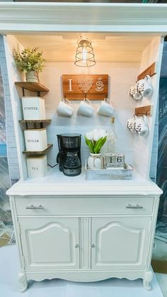 a white cabinet with some cups on top of it