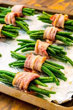 asparagus wrapped in bacon on a baking sheet