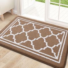 a brown and white rug on the floor in front of a sliding glass door with an open window