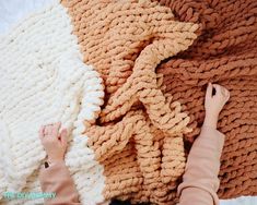 someone is laying down on a blanket with their hands