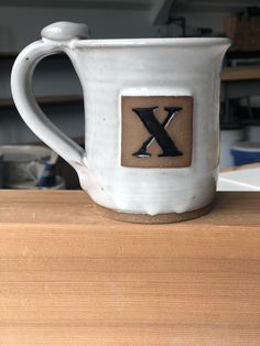 a white coffee cup sitting on top of a wooden table