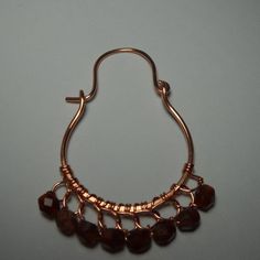 a close up of a metal object on a white surface with some beads hanging from it