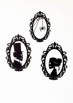 three black and white silhouettes of people in oval frames with spider on the wall