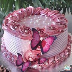 a cake with pink frosting and butterflies on it