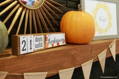 two wooden blocks with numbers on them are sitting next to a pumpkin and a clock