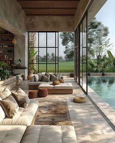 a living room filled with furniture next to a swimming pool