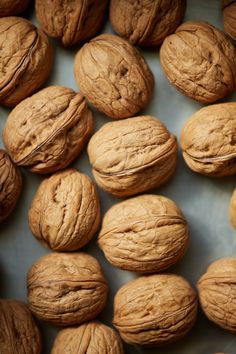 walnuts are arranged in rows on top of each other, with the kernels still intact