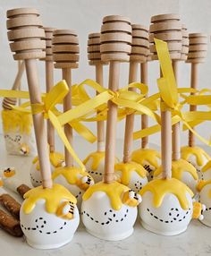 some yellow and white candies with wooden sticks sticking out of them