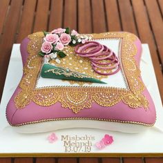 a pink and gold decorated cake sitting on top of a white plate